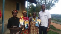 Kangabe Alibera (86) receiving solar lamp from Sam Munderere  of SURF