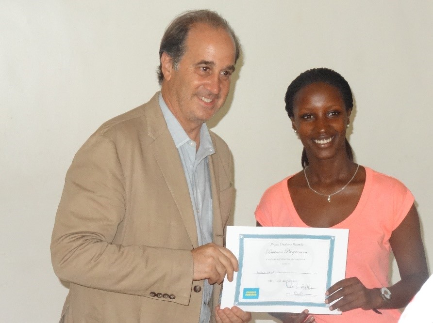 Kevine receiving her certificate of completion from Brooks Newmark (Project Umubano Member)