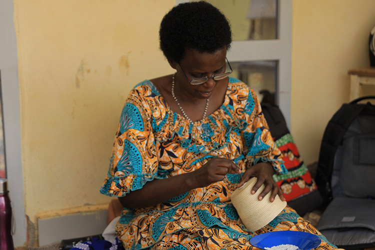 Anastasie Mukayiranga weaving a traditional basket (The New Times)