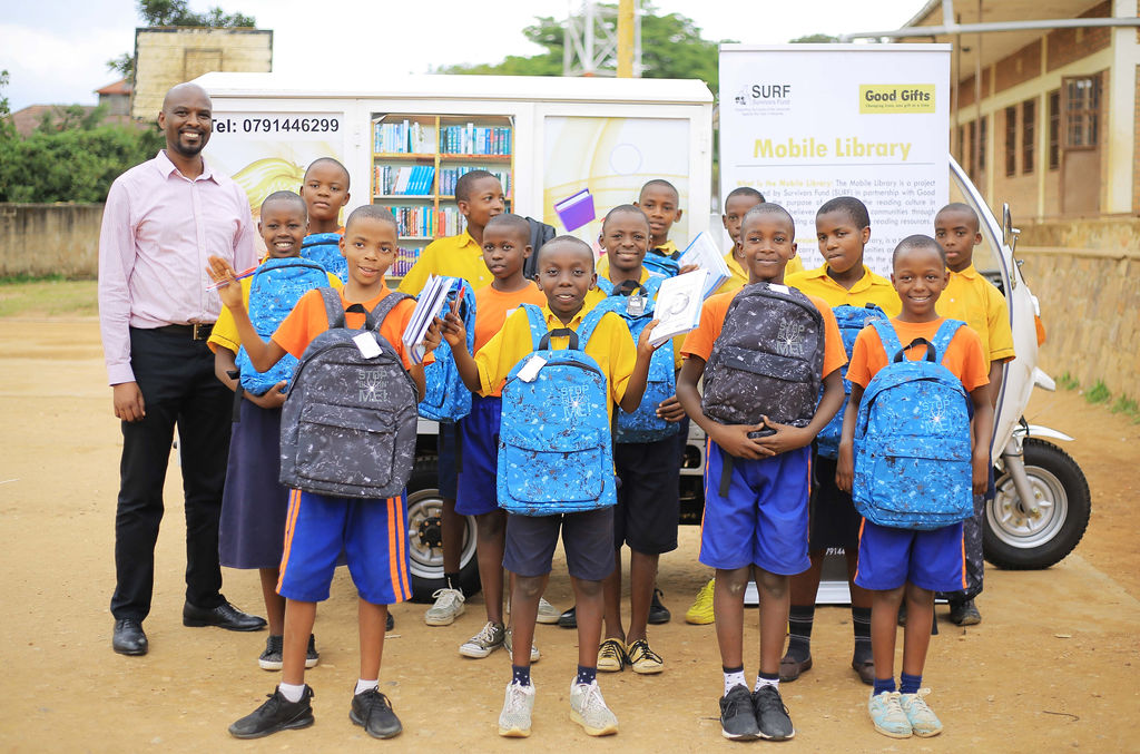 SURF Chief Executive, Samuel Munderere, with winners of the storywriting competition launched with the Good Gifts Mobile Library